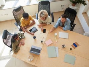 Image Article Quatre Personnes Travaillant Autour Dune Table