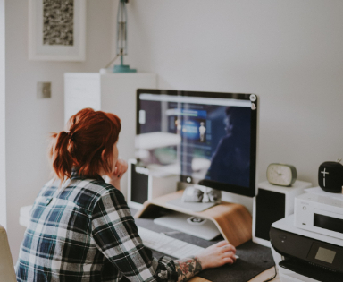 femme devant ordinateur bureau blanc