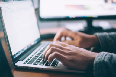 doigts tapant sur un clavier d'ordinateur portable
