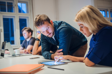 homme discutant avec une femme sur une tablette en réunion sur un bureau