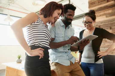 employees discussing in office with tablet