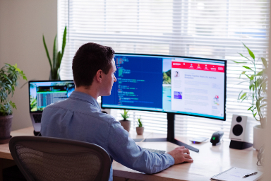 Homme devant ordinateurs bureau fenetre e-learning
